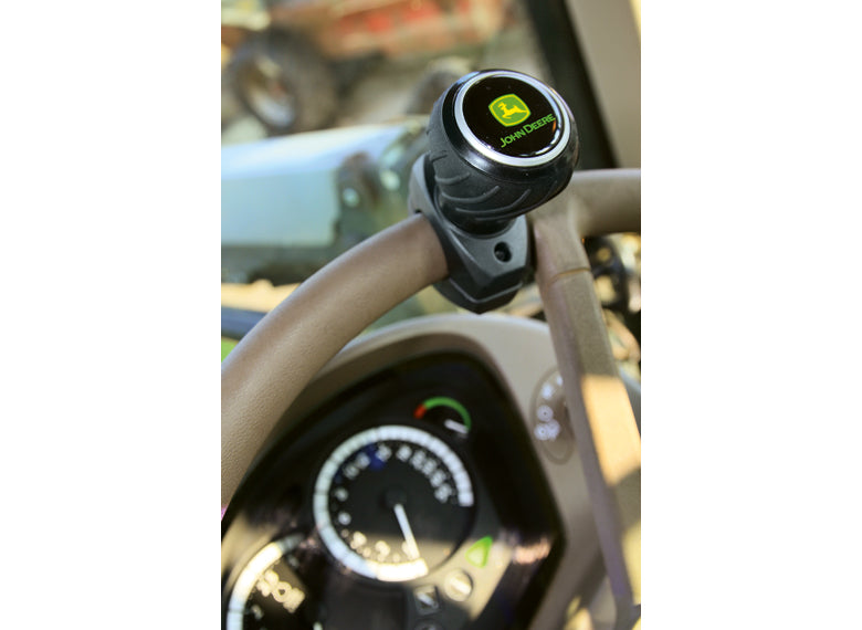 The John Deere Deluxe steering wheel spinner being used on a steering wheel