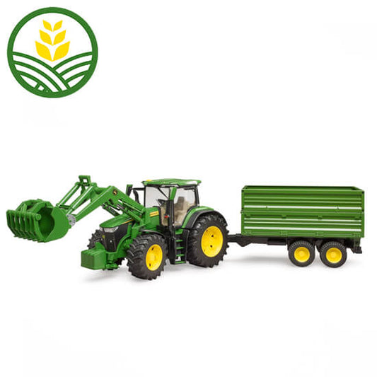 Model John Deere 7R 350 tractor with loader with a grab. Towing a green grain trailer.